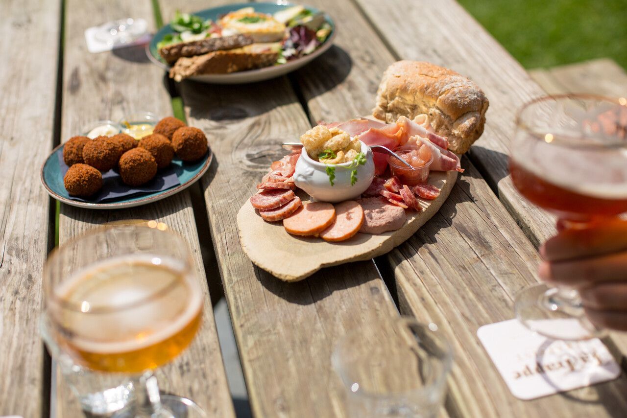 Een tafel met borrelhapjes en La Trappe biertjes