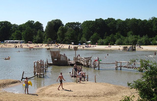 Ein Schwimmteich mit Spielgeräten, wo Kinder spielen und schwimmen.