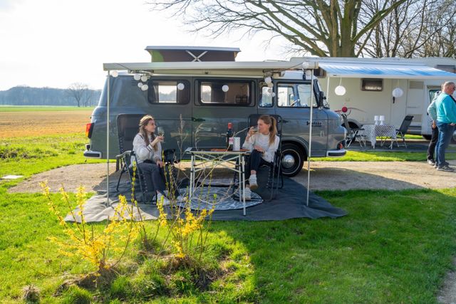 Twee dames die drinken bij camper op Camperplaats Biest-Houtakker