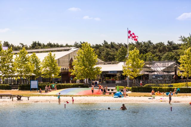 Uitzicht over het water van het strand en de grote trampoline bij TerSpegelt