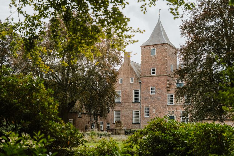 Gevel van Sint-Catharinadal gezien door bomen en struiken