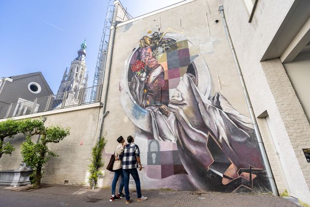 Twee mannen kijken naar een van de kunstwerken van de Blind Walls Gallery in Breda
